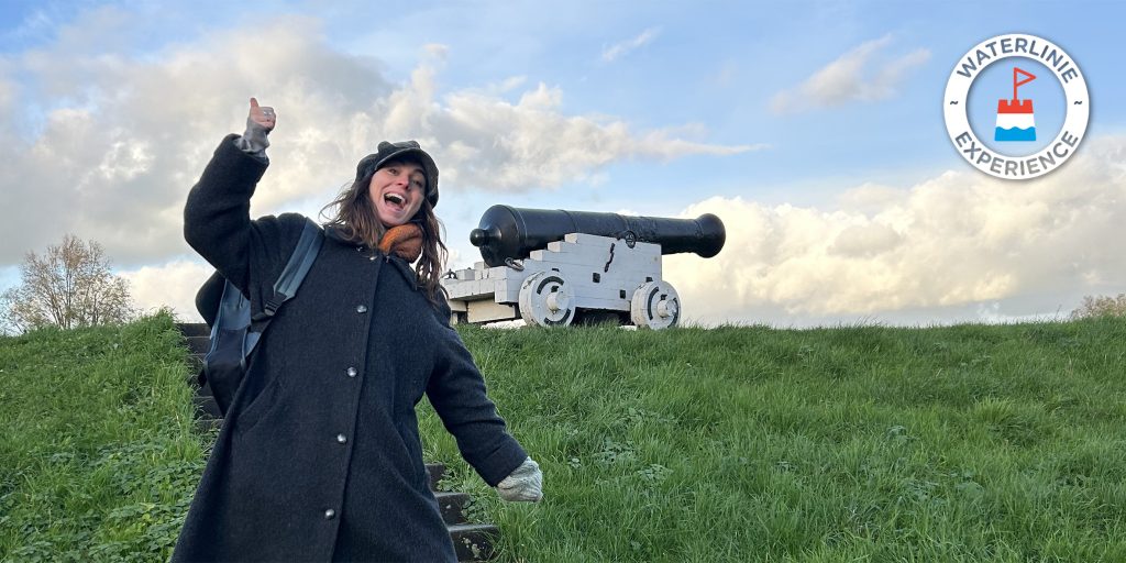Vlogster Nina voor een kanon op de Lekdijk in Nieuwpoort