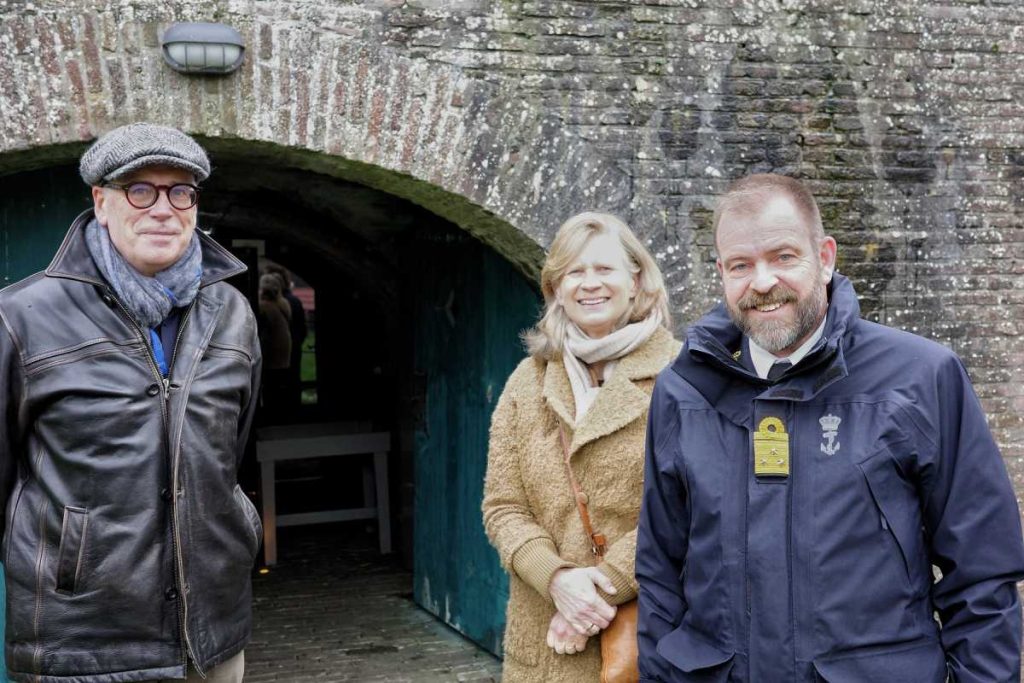 Twee begeleiders samen met Rene Tas aan de rechterkant tijdens hezoek van viceadmiraal René Tas aan het Nederlands Vestingmuseum in Naarden